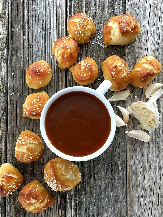 pretzel bites surrouding a cup of sauce and garlic