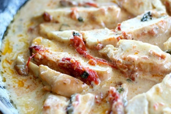 close up of pieces of chicken in sauce 